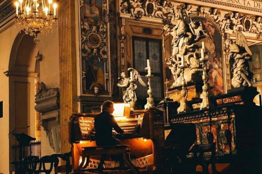A person playing a grand piano in a richly decorated room with ornate sculptures and a large painting. 2