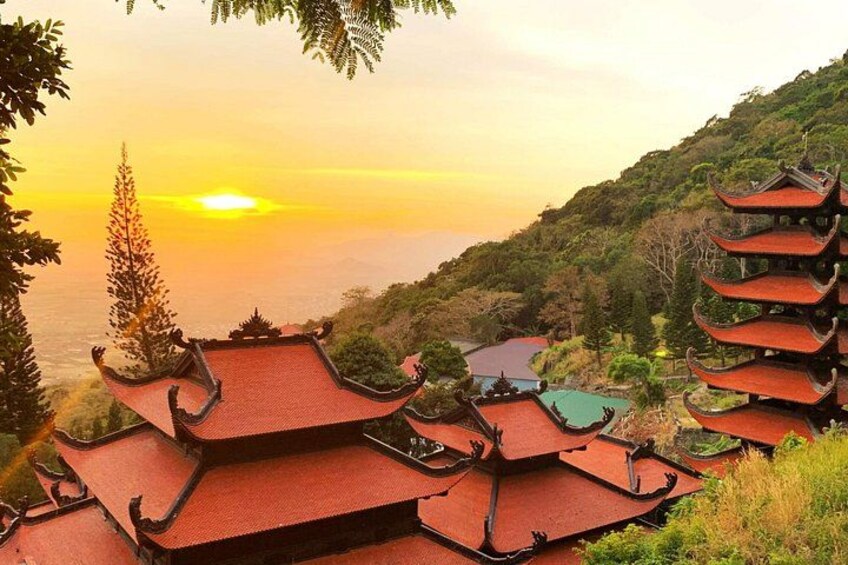 Un edificio de estilo pagoda con varios niveles, rodeado de exuberante vegetación y con vistas a un valle. 1