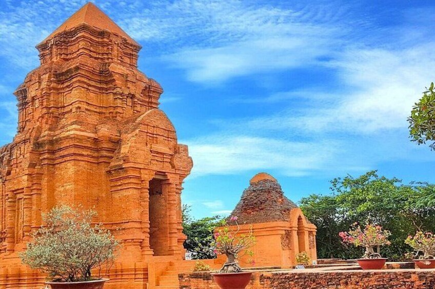 Un templo grande y antiguo de ladrillo con techo puntiagudo y una estructura más pequeña con techo cónico. 2