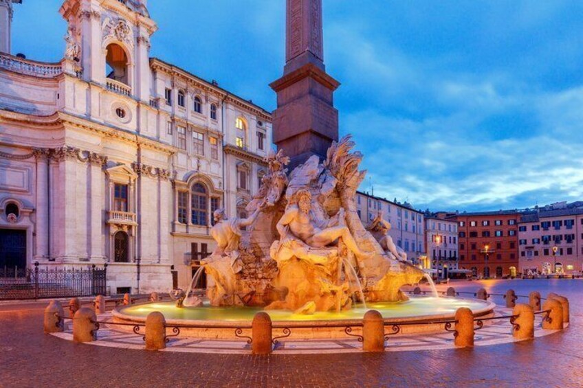 A grand fountain with statues, surrounded by a square with buildings in the background. 2