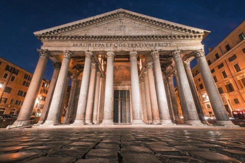 A classical building with columns and inscriptions, surrounded by urban architecture. 5