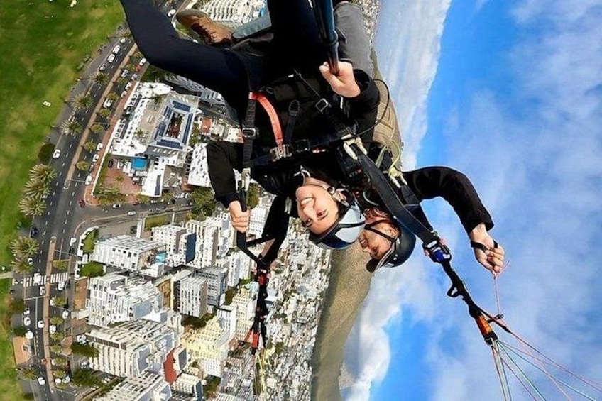 A person skydiving with a parachute over a cityscape. 2