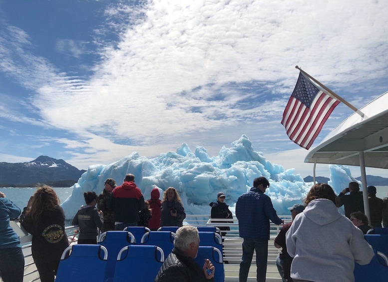 A group of people on a boat observing large icebergs in a glacier bay. 3