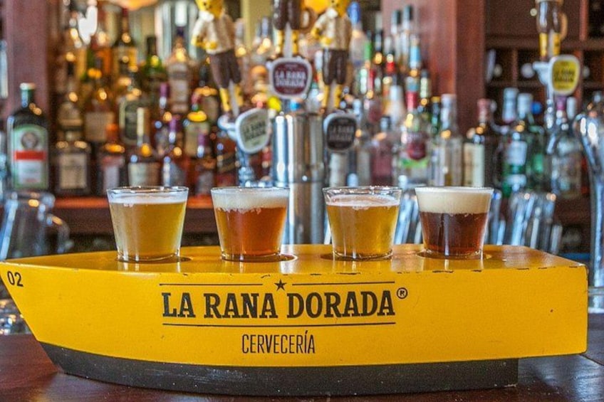 Una barra amarilla con cuatro vasos de cerveza y una grifo de cerveza al fondo. 3