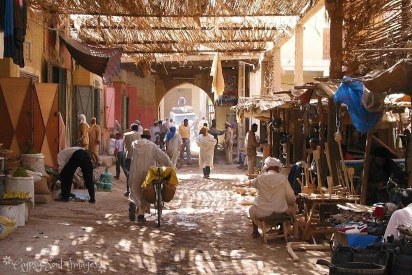 A bustling market street with people shopping and vendors selling goods. 5