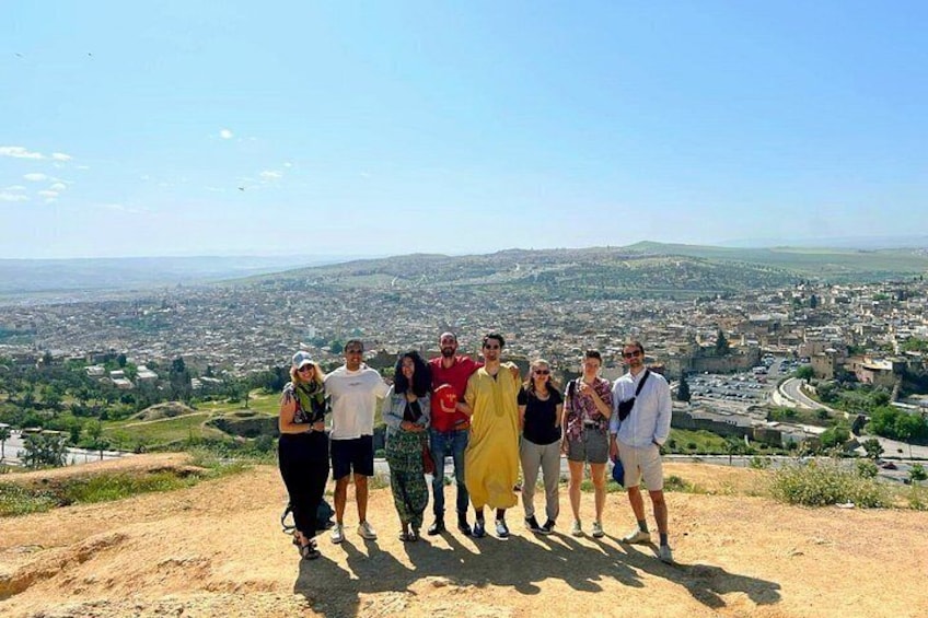 A group of people standing on a hill overlooking a cityscape with a clear sky. 4