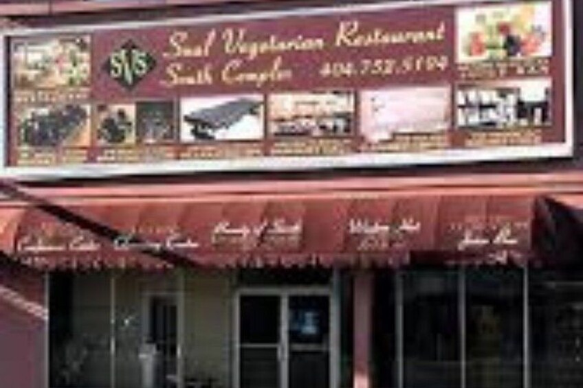 En butikslokal med en skylt som visar att det är en vegetarisk restaurang. 2