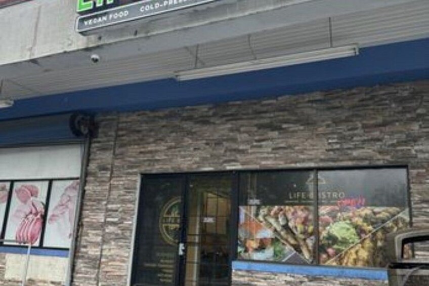 En byggnad med en skylt som visar texten ”VEGANSK MAT” och ”PREMIUM – SERVERAS KYLT”. 4