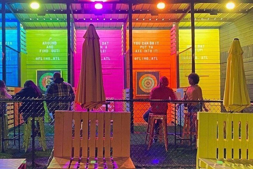 An outdoor seating area with colorful walls and tables. 1