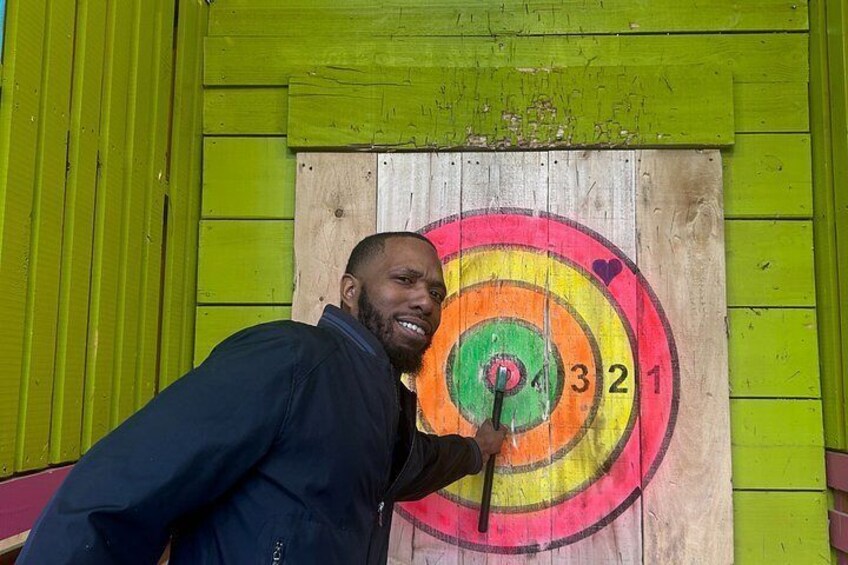 A person aiming an arrow at a colorful dartboard. 5