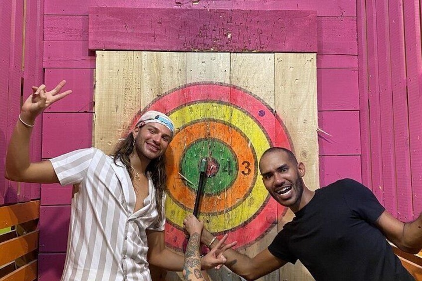Two people posing in front of a colorful target with a bullseye. 2