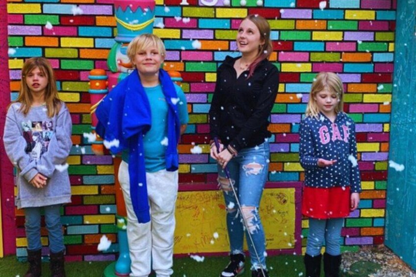 A colorful brick wall with children and an adult. 3