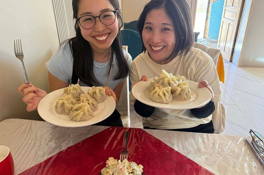 Dos personas sentadas a una mesa con platos de dumplings. 4