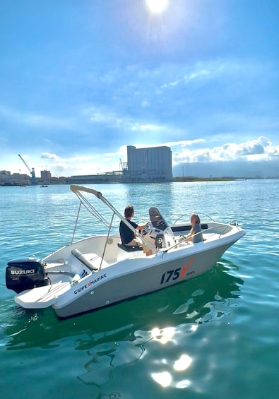 A boat named 'GIUPEXMARINE' with the number '175' on the side, floating on calm water with a cityscape in the background. 1