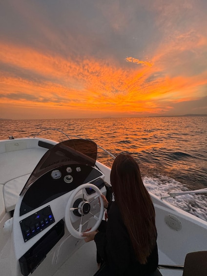 A boat steering wheel, dashboard, and a person with long hair. 2