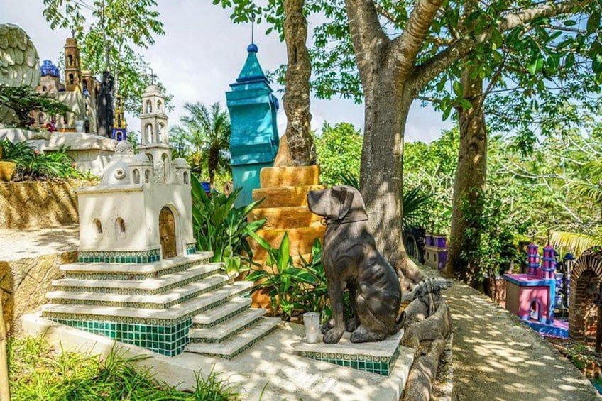 Een miniatuurarchitectuurmodel met een standbeeld van een hond, een klein gebouw en een toren. 3