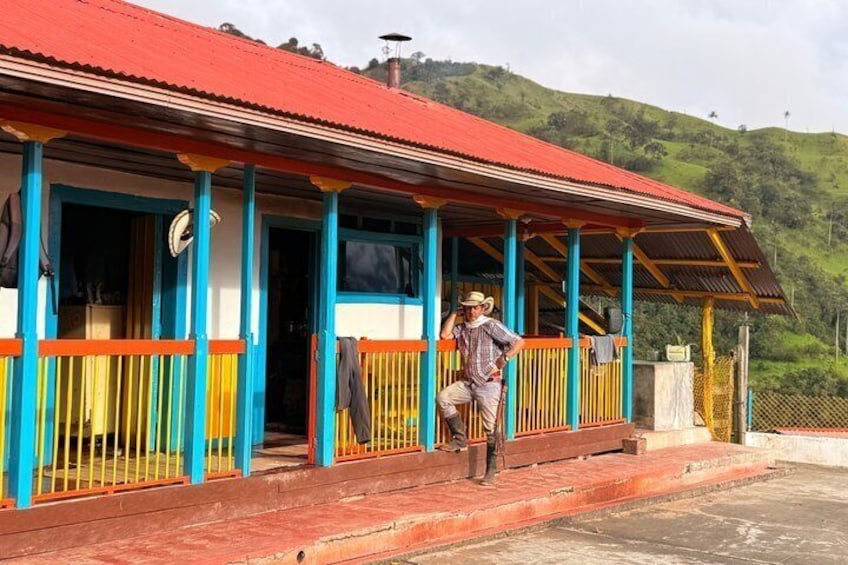 A colorful building with a red roof and blue and yellow accents, situated on a hillside. 2