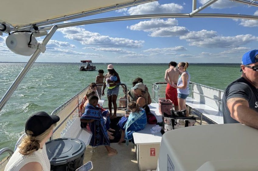 A boat with people on deck, water, and a distant shoreline. 2