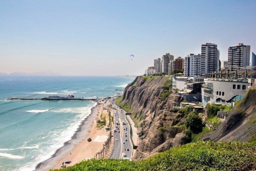 A coastal cityscape with a beach, cliffs, and high-rise buildings. 3