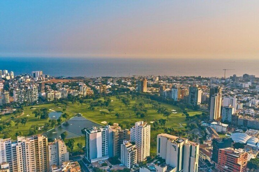 A coastal cityscape with high-rise buildings, a central park, and a body of water. 5