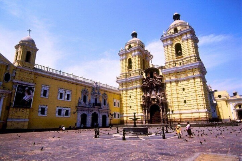 A historic yellow building with two towers and a central entrance. 4