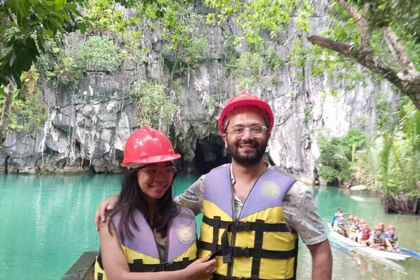 Deux personnes portant des gilets de sauvetage et des casques, une falaise rocheuse et un bateau sur une rivière. 4