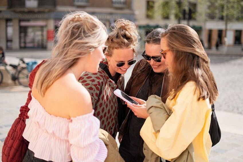 En grupp människor står på en gata, och en av dem håller i en smartphone. 4