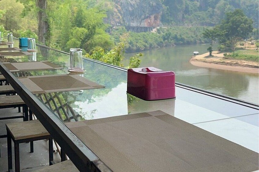 Una mesa de vidrio con sillas frente a un río. 2