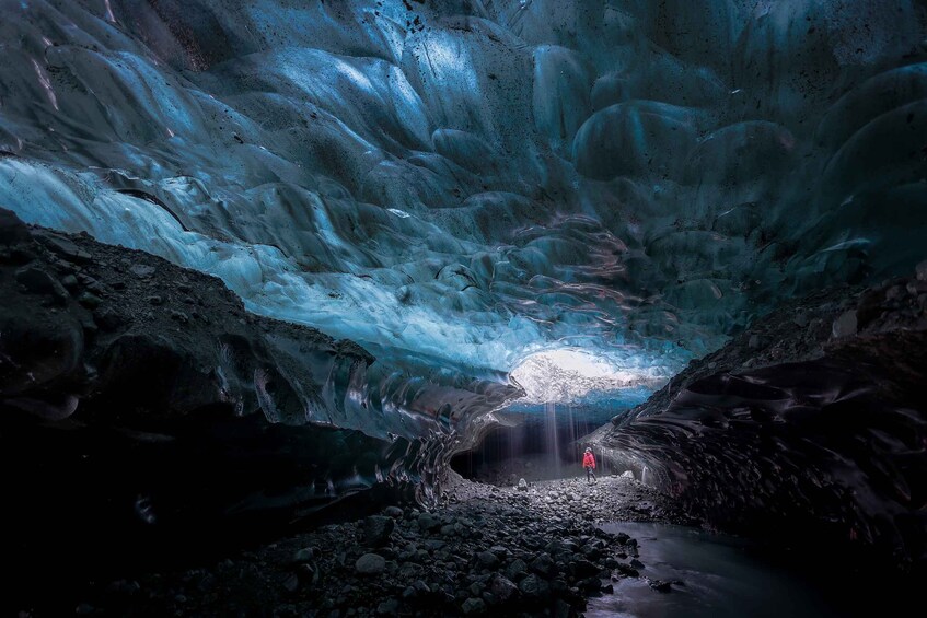 Une grotte de glace dans laquelle se trouve une personne, debout au centre. 1