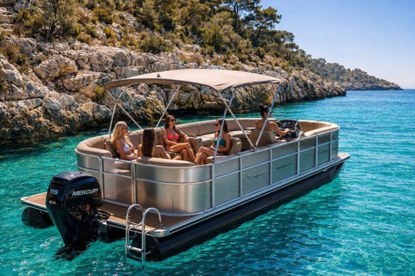 A boat with people on it, surrounded by clear blue water and rocky terrain. 4