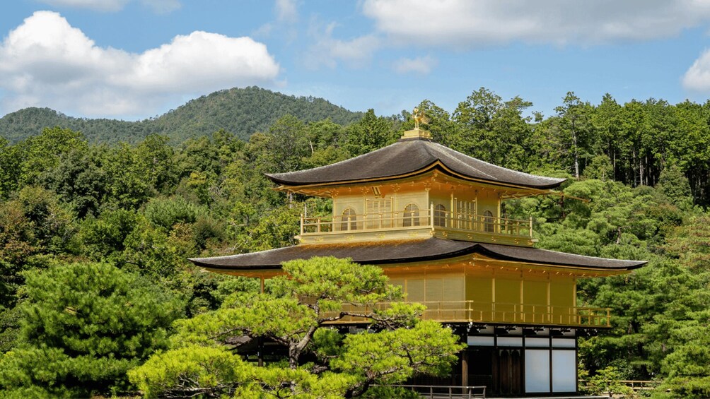 A traditional Japanese pagoda with a thatched roof, surrounded by lush greenery and mountains. 2