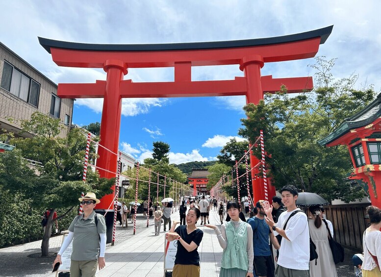A red torii gate with a clear sky and a crowd of people in front. 1