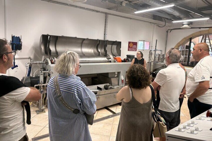 A group of people in a kitchen observing a cooking demonstration. 3