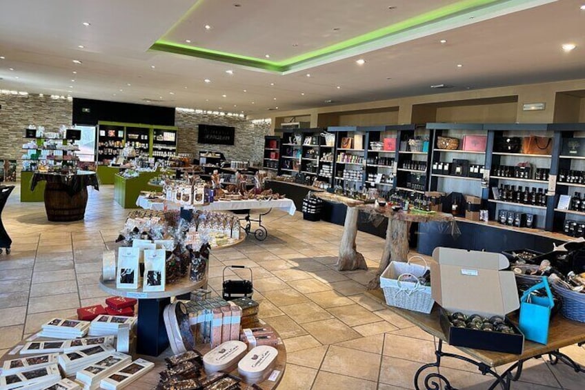 A retail store with shelves of products, a display table with items, and a checkout counter. 2