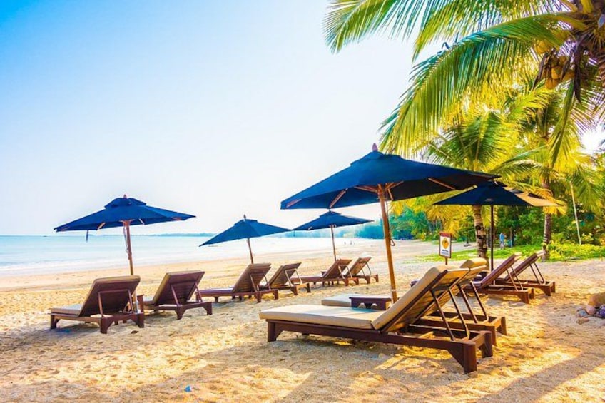 A beach with lounge chairs and umbrellas. 1