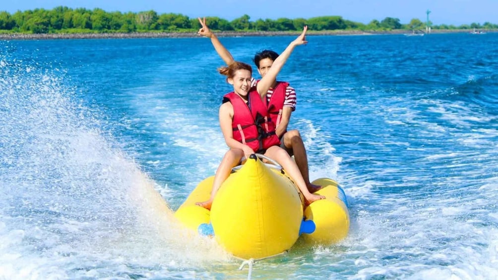 Two people on a yellow watercraft in a body of water with a clear sky. 4