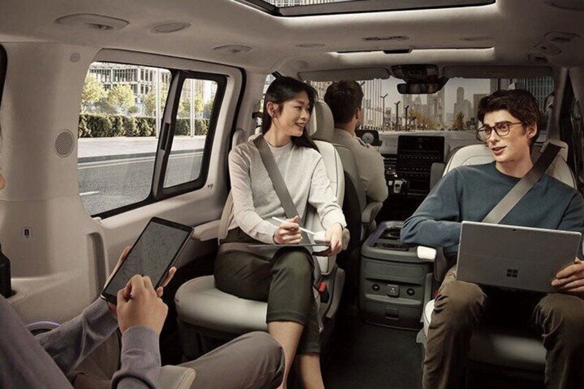 Innenraum eines Fahrzeugs mit Fahrgästen, die Laptops und Tablets benutzen. 4