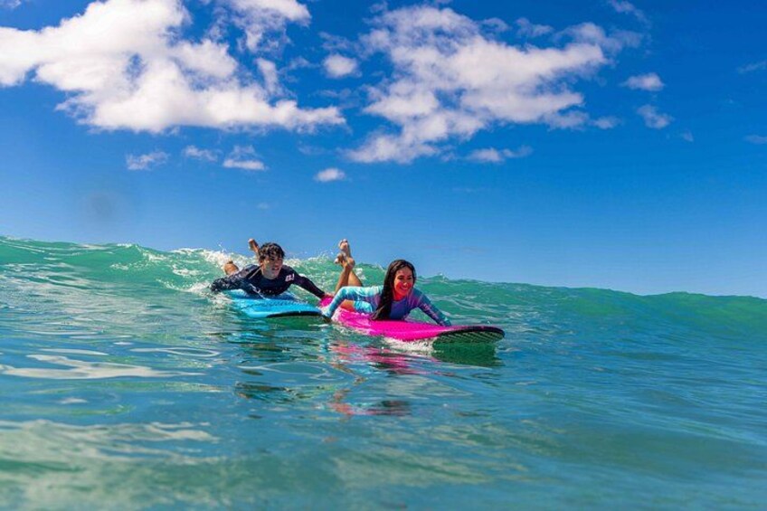 Deux personnes sur des planches de surf dans l’océan, sous un ciel dégagé. 3
