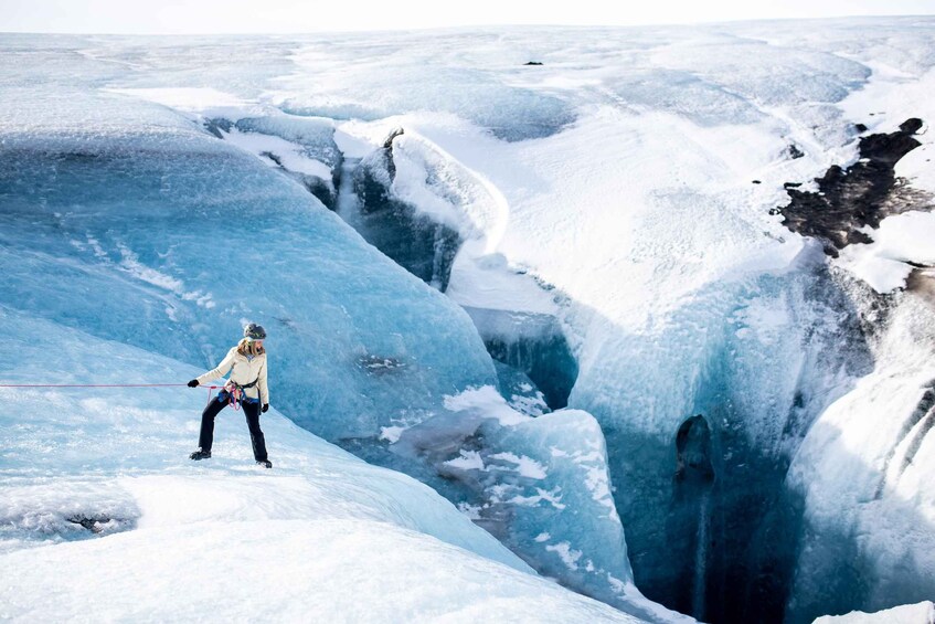 A person ice climbing on a glacier. 2