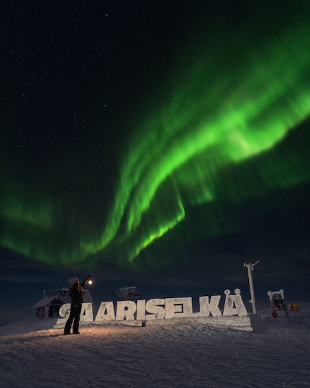 A person observing the Northern Lights at a location marked 'MARISJELKA.' 1