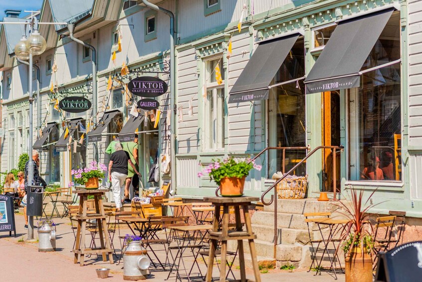 A street with outdoor seating and a building with signs for 'VIKTOR CRAFTS & DESIGN' and 'GALLERIE.' 5