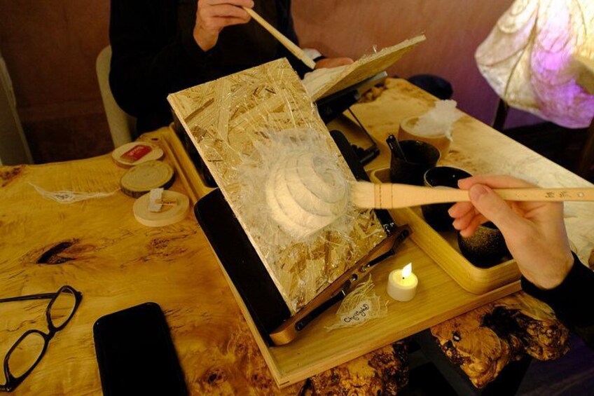 A person carving a wooden object with a carving tool. 5