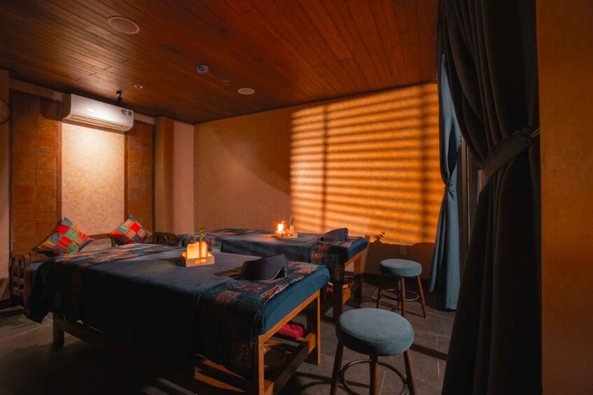 A room with two beds, a table, and a chair. 2