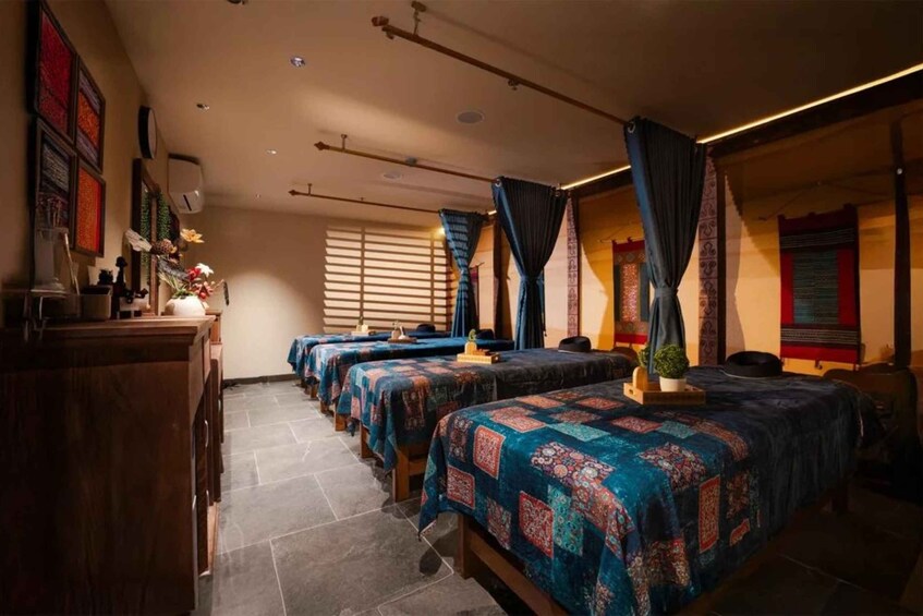 A hotel room with multiple beds, a wooden dresser, and a window with blinds. 4