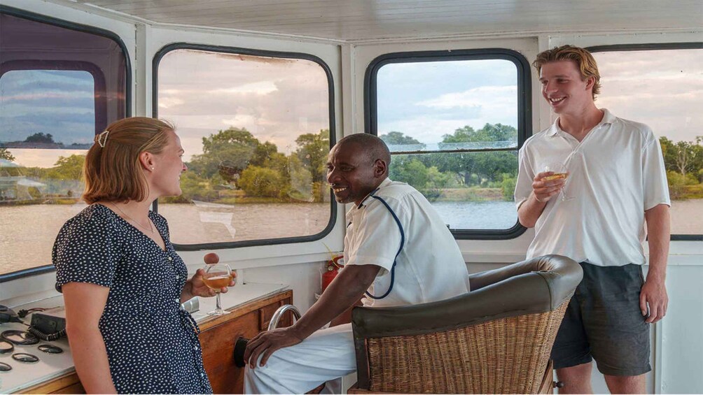 A boat interior with a view of a river and trees. 3