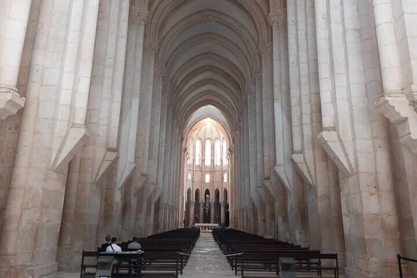 Ein Kathedraleninneres mit hohen Gewölbedecken und Reihen von Kirchenbänken. 5