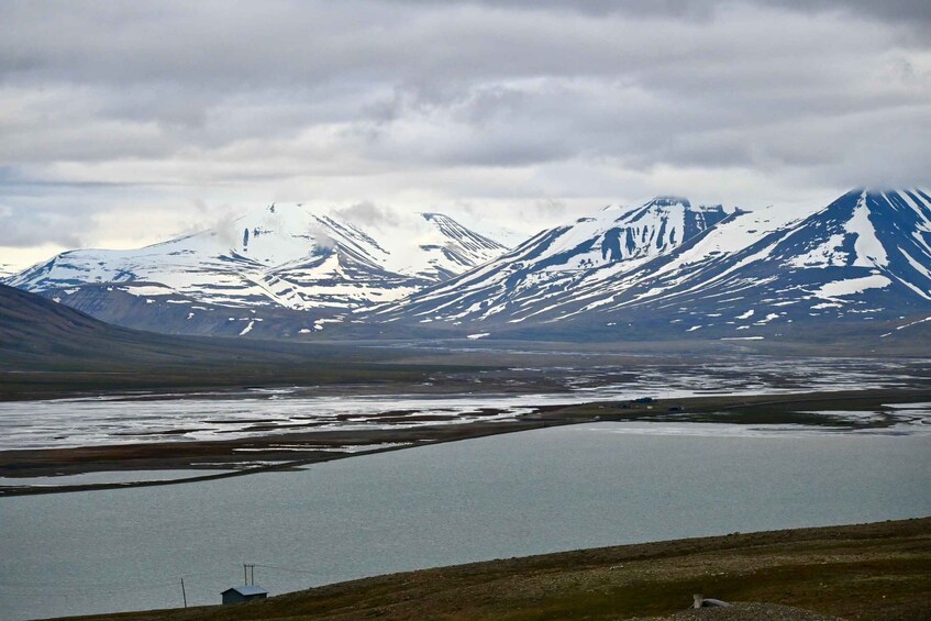 A mountainous landscape with snow-capped peaks and a body of water in the foreground. 4
