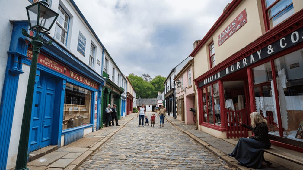 A cobblestone street lined with shops, including a wine store and a sewing machine shop. 3
