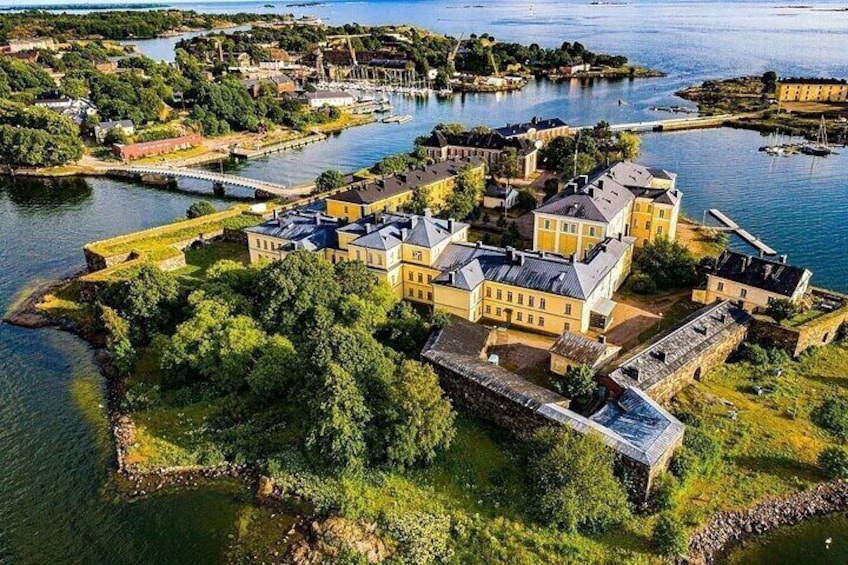 A coastal town with a prominent yellow building, a marina, and a bridge connecting to the mainland. 2