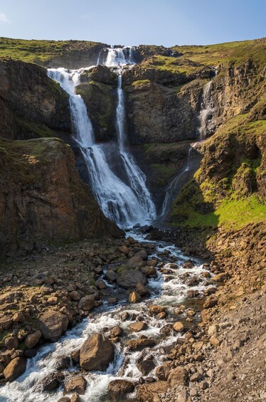 A multi-tiered waterfall cascading over rocky terrain with a river flowing below. 5